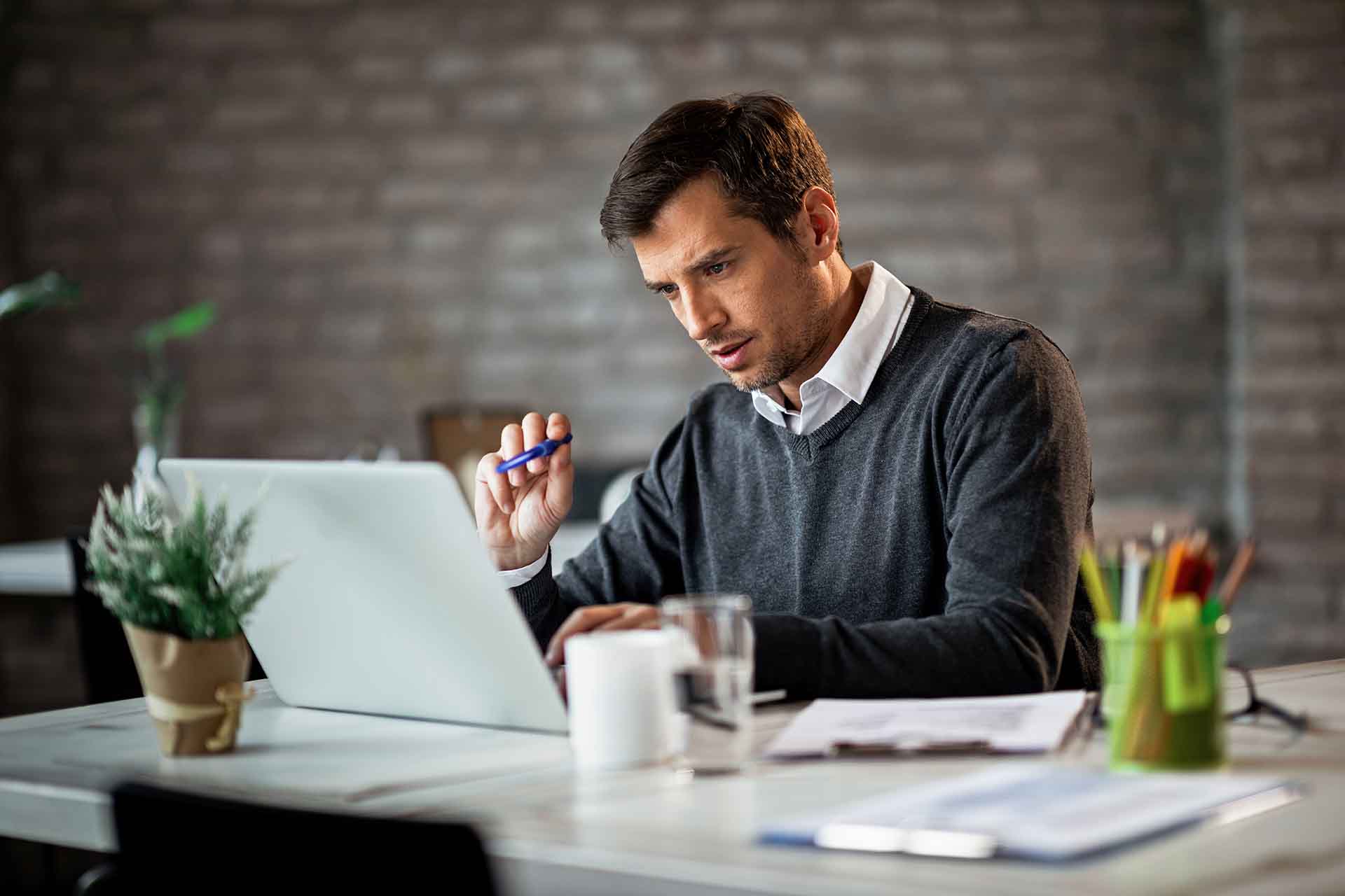 Uomo che lavora al computer in ufficio moderno.